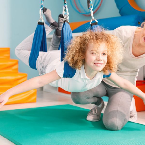 Boy and his therapist exercising during sensory integration therapy
